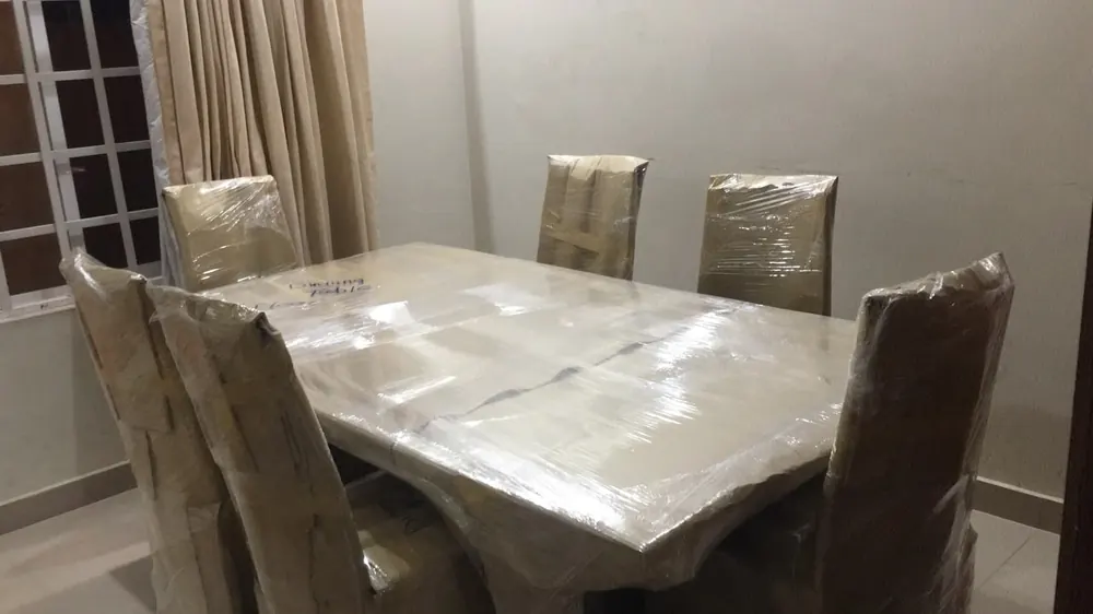 Dining table and chairs stretch-wrapped by Marsoos movers in Islamabad