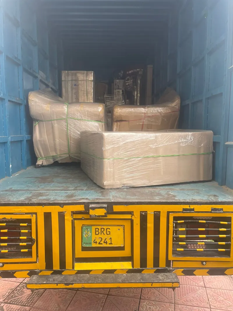 Crew loading packed furniture onto a house-shifting truck